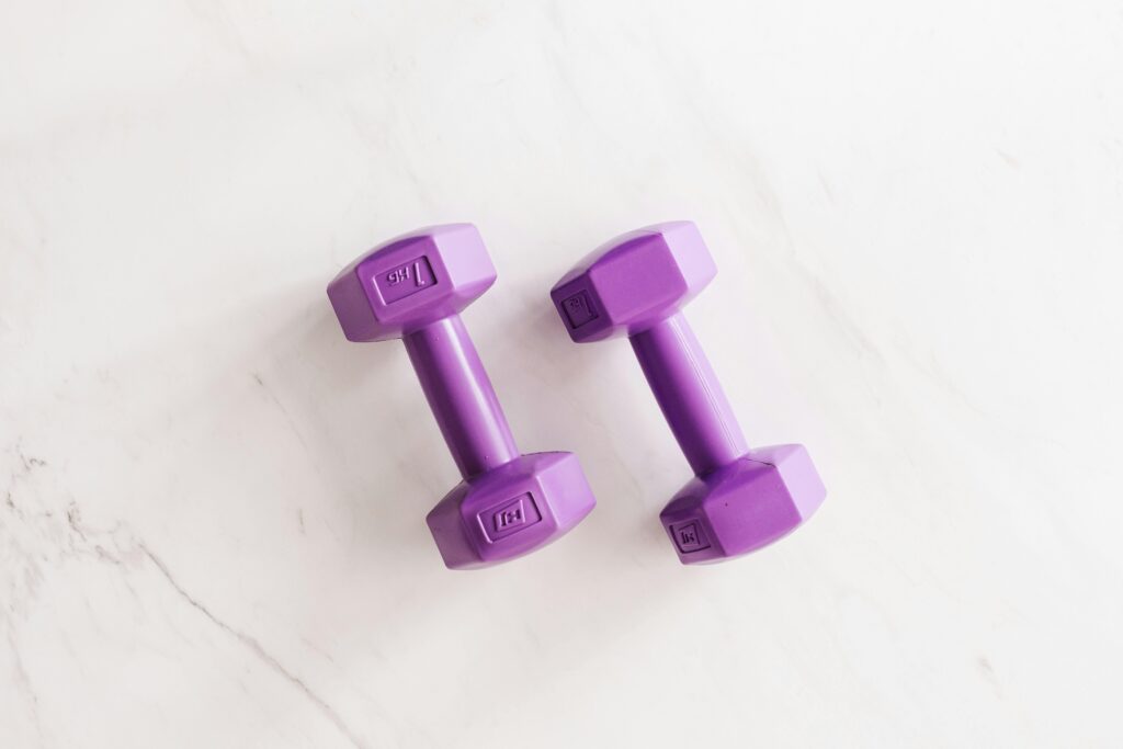 Top view of purple unit cast dumbbell of seven kilo weight placed on white marble surface