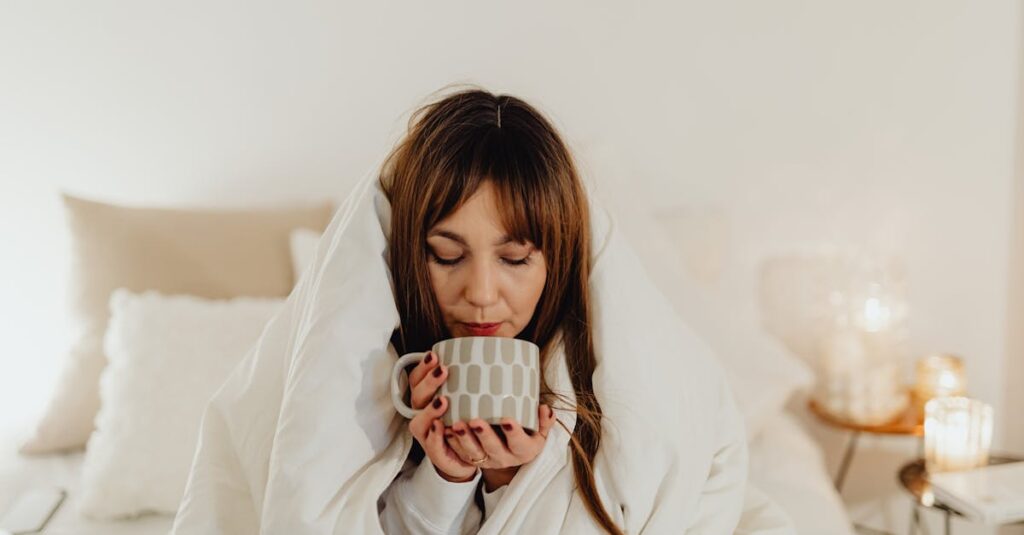 A woman wrapped in a blanket enjoys a hot drink, creating a cozy and serene morning atmosphere.